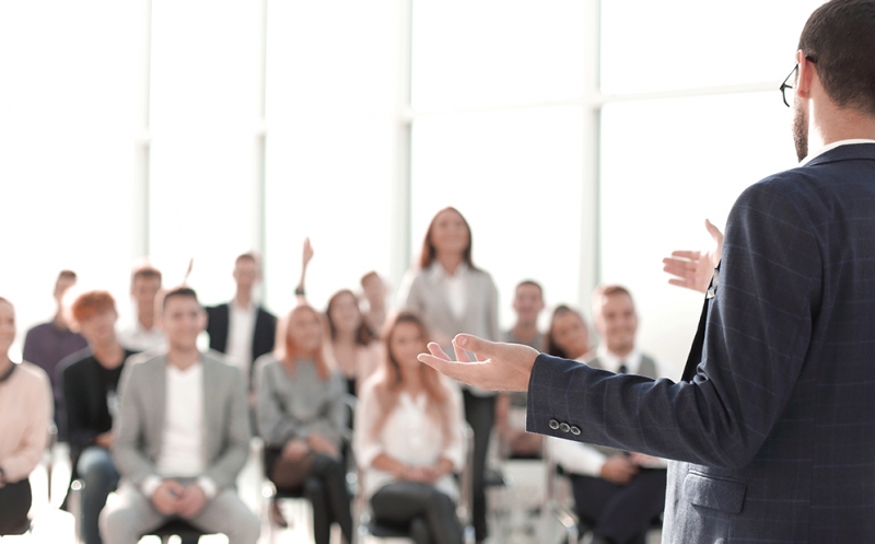 primo-piano-dell-altoparlante-in-piedi-di-fronte-al-pubblico-nella-sala-conferenze-low